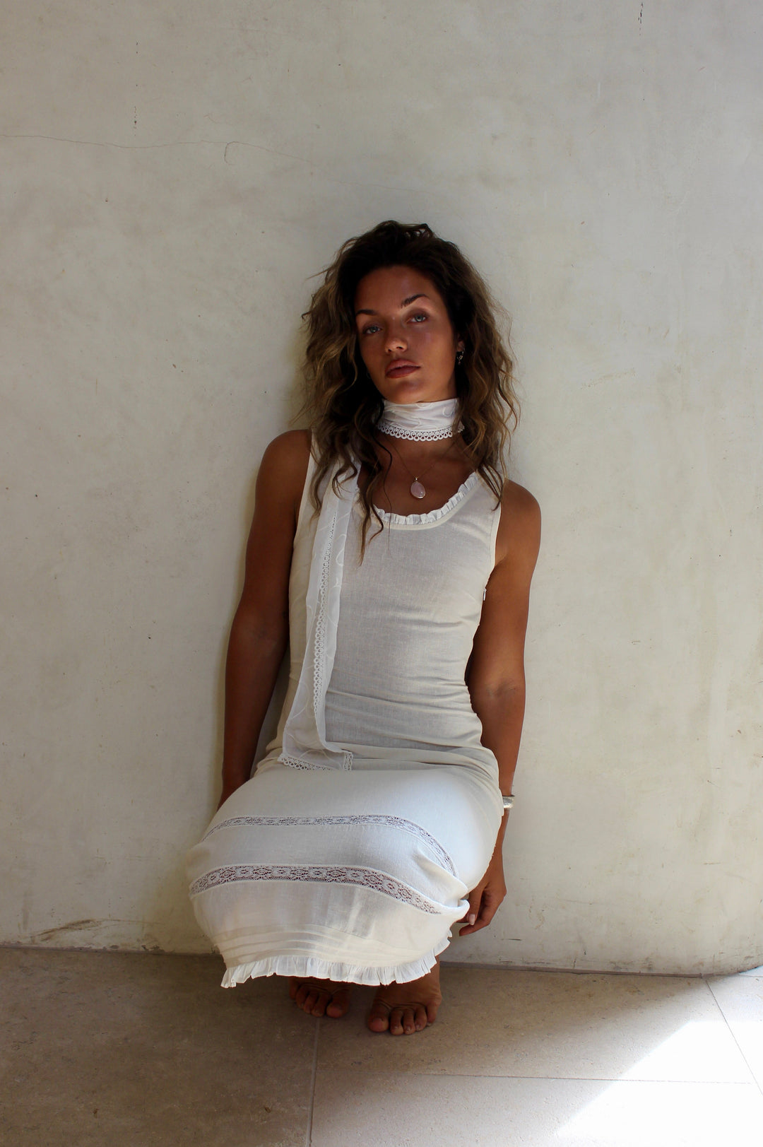 White scarf, with hand drawn embroidery and a lace detail. 